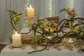 wedding table decoration, forest theme, branches, flowers and candle.