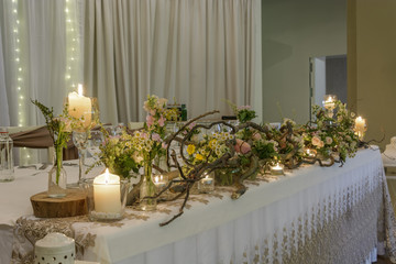 wedding table decoration, forest theme, branches, flowers and candle.
