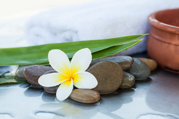 Fototapeta na wymiar Spa flower and stones and towel for massage treatment