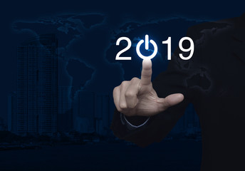 Businessman pressing 2019 start up business icon over world map and modern city tower, Happy new year concept, Elements of this image furnished by NASA