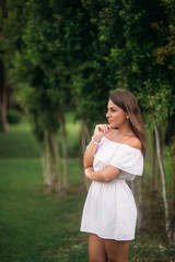 Fototapeta premium young and pretty girl in a summer city standing near the tree
