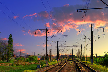 Fototapeta na wymiar Two lines railway at the country side on the beautiful sunset sky background. Electric poles at railroad.