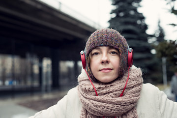 Woman in a hat and headphones listening to music on the street