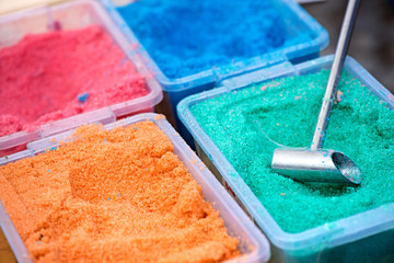 Dyed food coloring sugar crystal boxes ready to create colorful cotton candy for children. Variety of colors sold by street clowns
