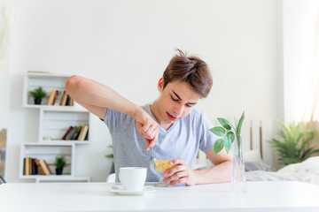Young man drinking coffee and having breakfast