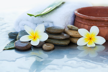Obraz na płótnie Canvas spa objects with towel and stones for massage treatment on white background.