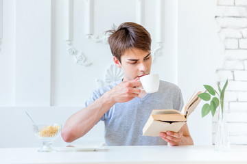 Young man drinking coffee and having breakfast
