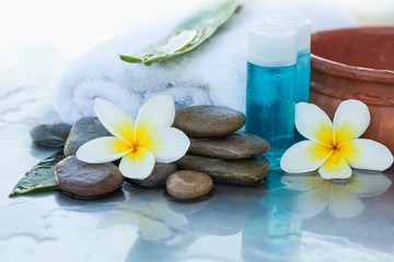 Spa Tube with oil for massage and flowers and stones