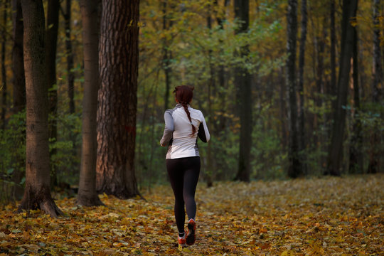 Photo from back in full growth of brunette running in forest