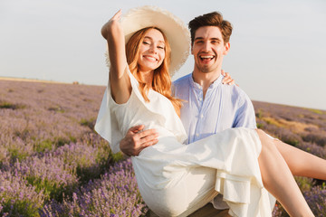 Smiling young couple having fun at the lavender field