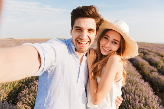 Beautiful young couple taking a selfie while hugging