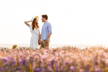 Photo of beautiful young people dating, and walking together outdoor in lavender field