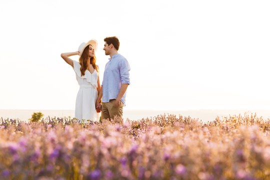 Photo of beautiful young people dating, and walking together outdoor in lavender field