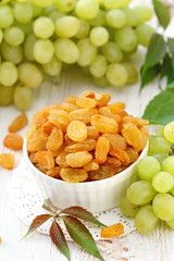 Dried raisins in a bowl and fersh grape