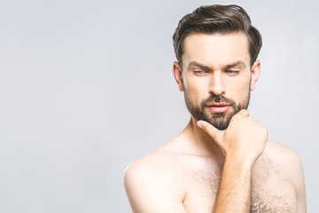 Photo of smiling young man standing isolated over grey wall background naked. Skincare concept.