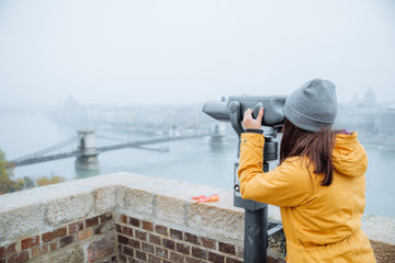 woman at observation deck looking into binocular