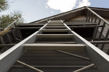 Senior man building a house by standing on scaffolding