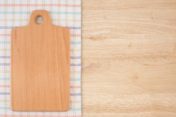 Cutting board on a kitchen napkin on old wooden table.