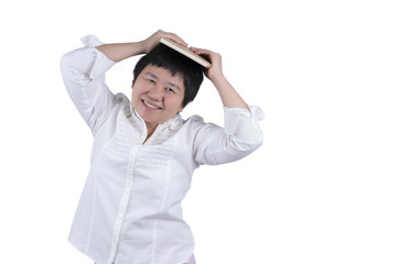 Smiling Asian Middle-aged woman in white shirt holding book over her head isolated on white background