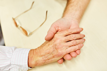 Hand eines Patienten halten als Trost