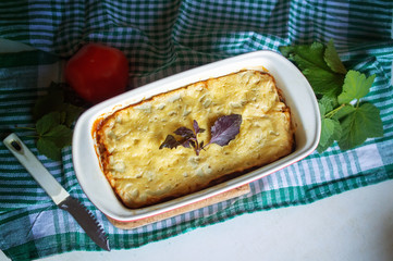 casserole with cheese and vegetables in the form is on table