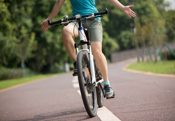 Fototapeta na wymiar happy woman cyclist riding bike in spring tropical park