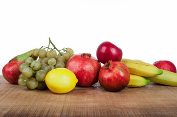 pomegranates and other fruits on a wooden table