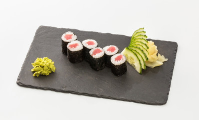 sushi rolls with salmon on a black plate isolated on a white background