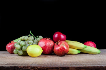 pomegranates and other fruits on a wooden table