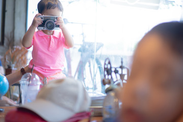 A boy is taking a Photo film camera.