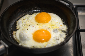 two eggs cooked in a black cast iron skillet