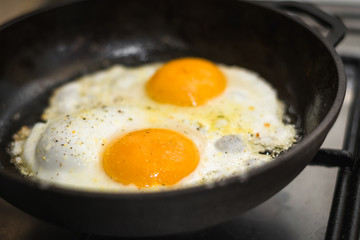 two eggs cooked in a black cast iron skillet