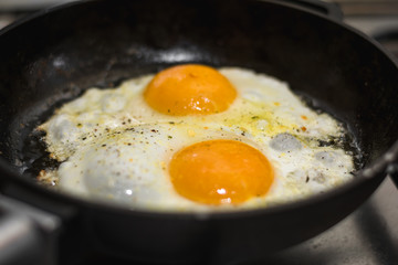 two eggs cooked in a black cast iron skillet