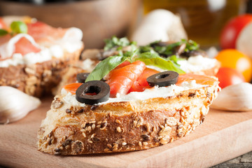 Italian tomato and cheese bruschetta. Tapas, antipasti with chopped vegetables, herbs and oil on grilled ciabatta and baguette bread.