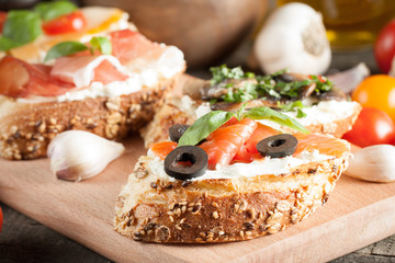 Italian tomato and cheese bruschetta. Tapas, antipasti with chopped vegetables, herbs and oil on grilled ciabatta and baguette bread.