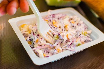 salad in a plastic container with a fork