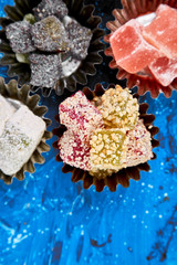 Set of various Turkish delight in bowl on blue background