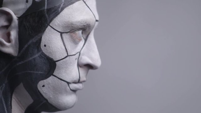 Side view of a cyborg man looks up, close up