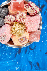 Set of various Turkish delight in bowl on blue background