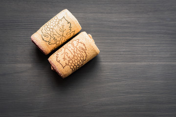 two vine corks on black wooden background with cope space