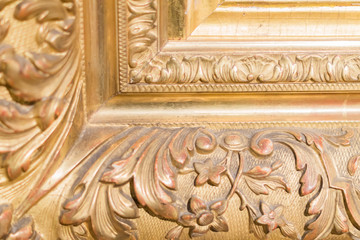 close up of rustic baguette of the painting. gold carved flowers and leaves