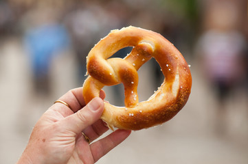 closeup of traditional salted pretzels  in hand of woman in the street