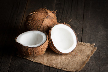 Ripe half cut coconut on a wooden background.  Coconut cream and oil.