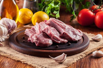 Raw fresh lamb chops on wooden cutting board