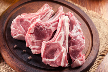 Raw fresh lamb chops on wooden cutting board