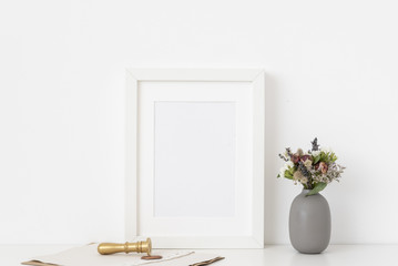 Stylish white a5 portrait frame mockup with cute bouquet of dried flowers.Background
