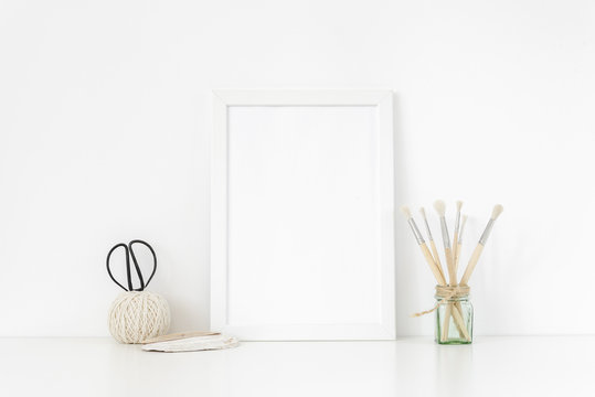 Elegant white frame portrait mockup A4 in interior with vintage elements. Frame mock up background for poster frame for social media, lettering, art and design. Indoor, frame on table. Back to school.