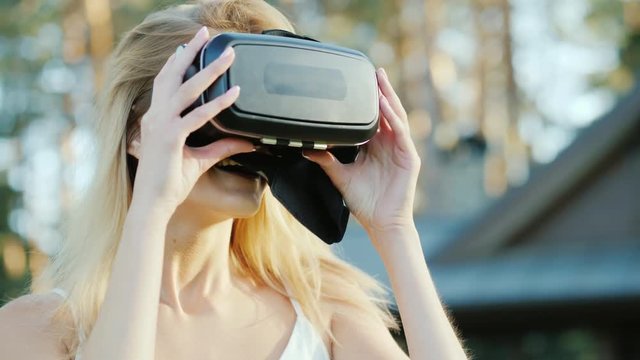 Happy caucasian woman invites into the world of virtual reality. Smiling, putting on 3d helmet on camera
