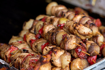 Close up of traditionally grilled pork and beef meat on a wooden stick. Eastern European traditional shish kebab with grilled vegetables.