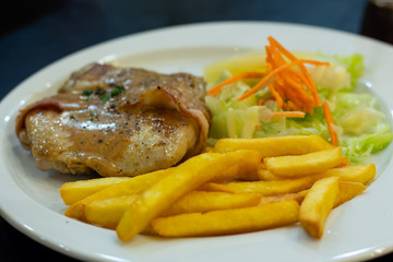 Chicken steak with French fries and salad.